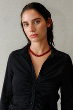 Load image into Gallery viewer, Woman wearing a black shirt and red necklace against a neutral background