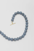 Load image into Gallery viewer, Blue beaded necklace with a gold clasp on a light grey background