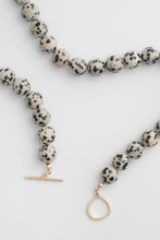 Load image into Gallery viewer, Necklace with dalmatian jasper beads and gold clasp on a light gray background