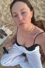 Load image into Gallery viewer, Woman wearing necklace at beach, holding glass of wine