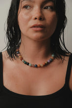 Load image into Gallery viewer, Close-up of a person wearing a colorful beaded necklace against a neutral background
