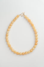 Load image into Gallery viewer, Necklace with yellow-coloured beads on a light grey background
